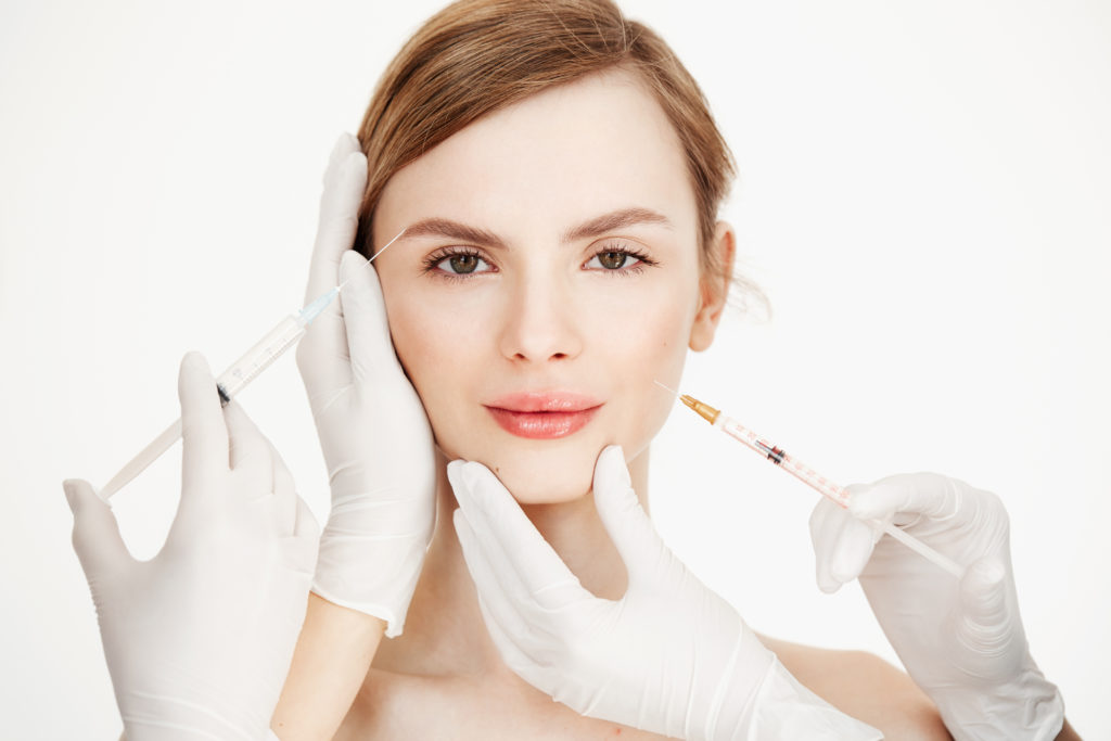 Manos de cosmetólogos haciendo inyecciones médicas para una hermosa mujer. Lifting de piel. Tratamiento facial-estética-rostro-Tanger Dental Center